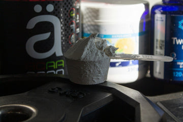 Supplement stack with protein shaker in gym setting