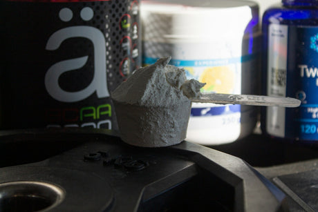 Supplement stack with protein shaker in gym setting
